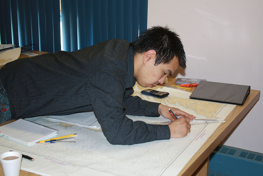 A student learns about chartwork at the Nunavut Fisheries Marine Training Consortium.