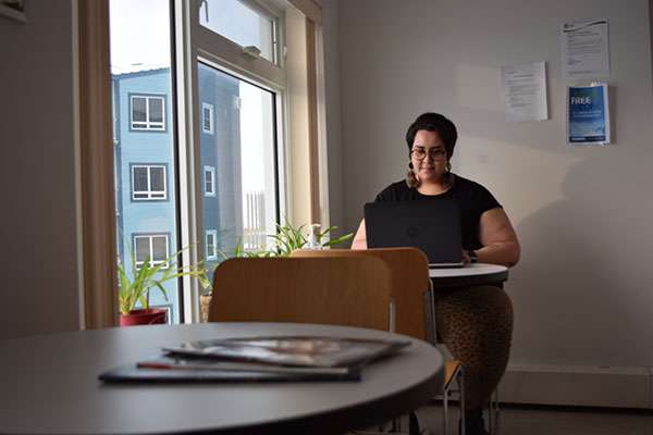 Inuk woman working at a laptop in a sunny office.